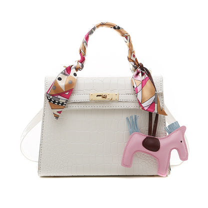 Stone pattern PU leather shoulder bag with a pink horse keychain and colorful scarf accents.