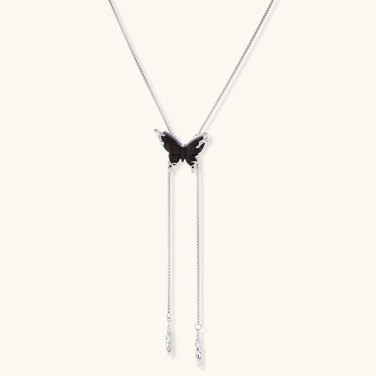 Wooden butterfly pendant necklace with cascading silver-toned chains on adjustable chain, available in amber and black.
