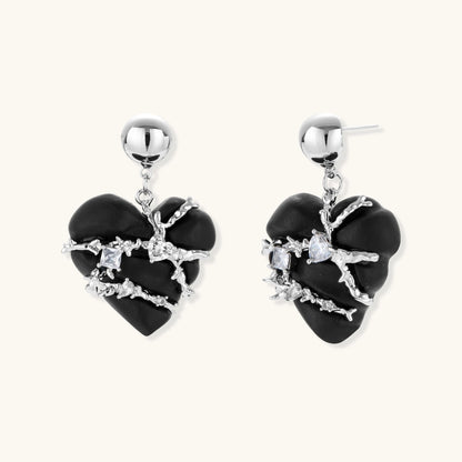 Black heart-shaped wood earrings with decorative silver chains and crystal accents hanging from silver ball studs
