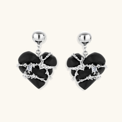 Black heart-shaped wood earrings with decorative silver chains and crystal accents hanging from silver ball studs