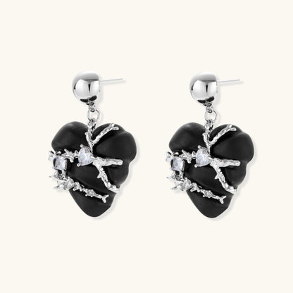 Black heart-shaped wood earrings with decorative silver chains and crystal accents hanging from silver ball studs