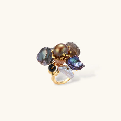 Adjustable gold-plated ring featuring clustered dark baroque pearls in organic arrangement on white background.